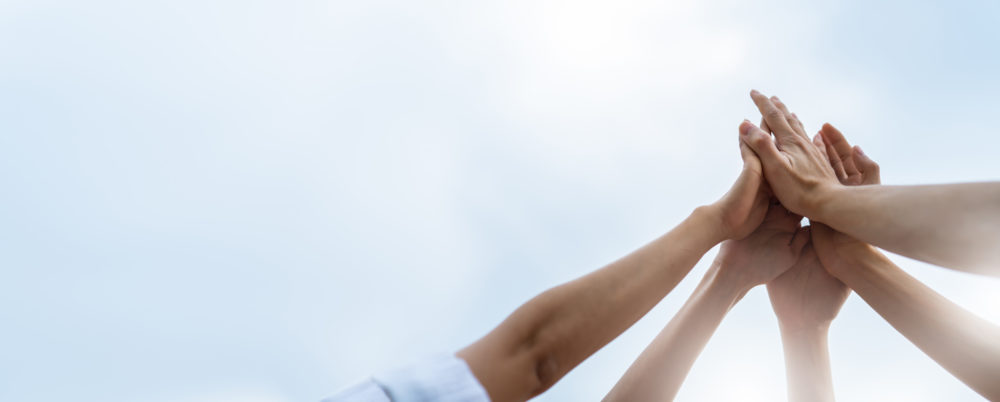 Yhdessä, useat kädet ilmassa "high five"